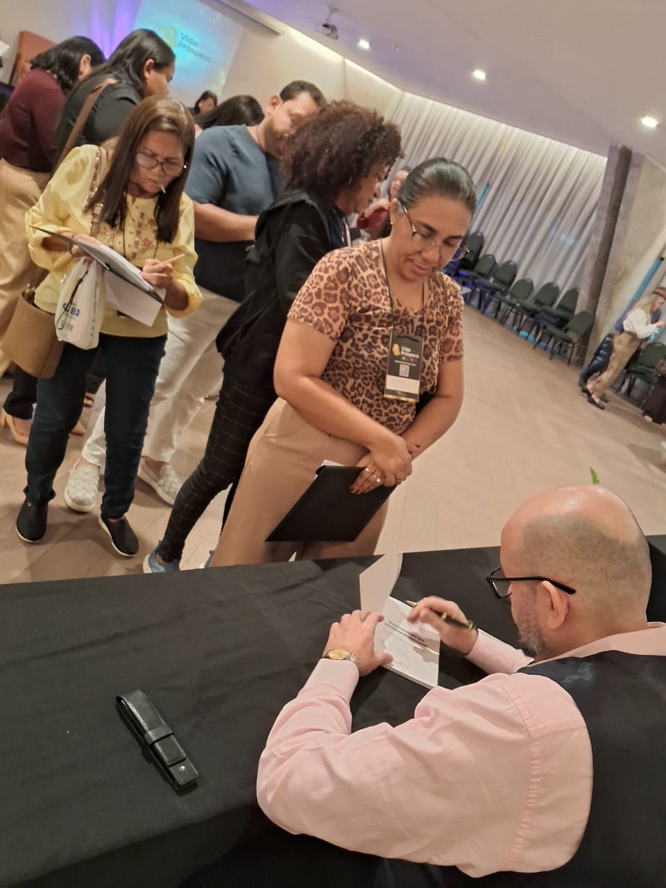 Momento de autógrafos e contato com leitores durante um evento.